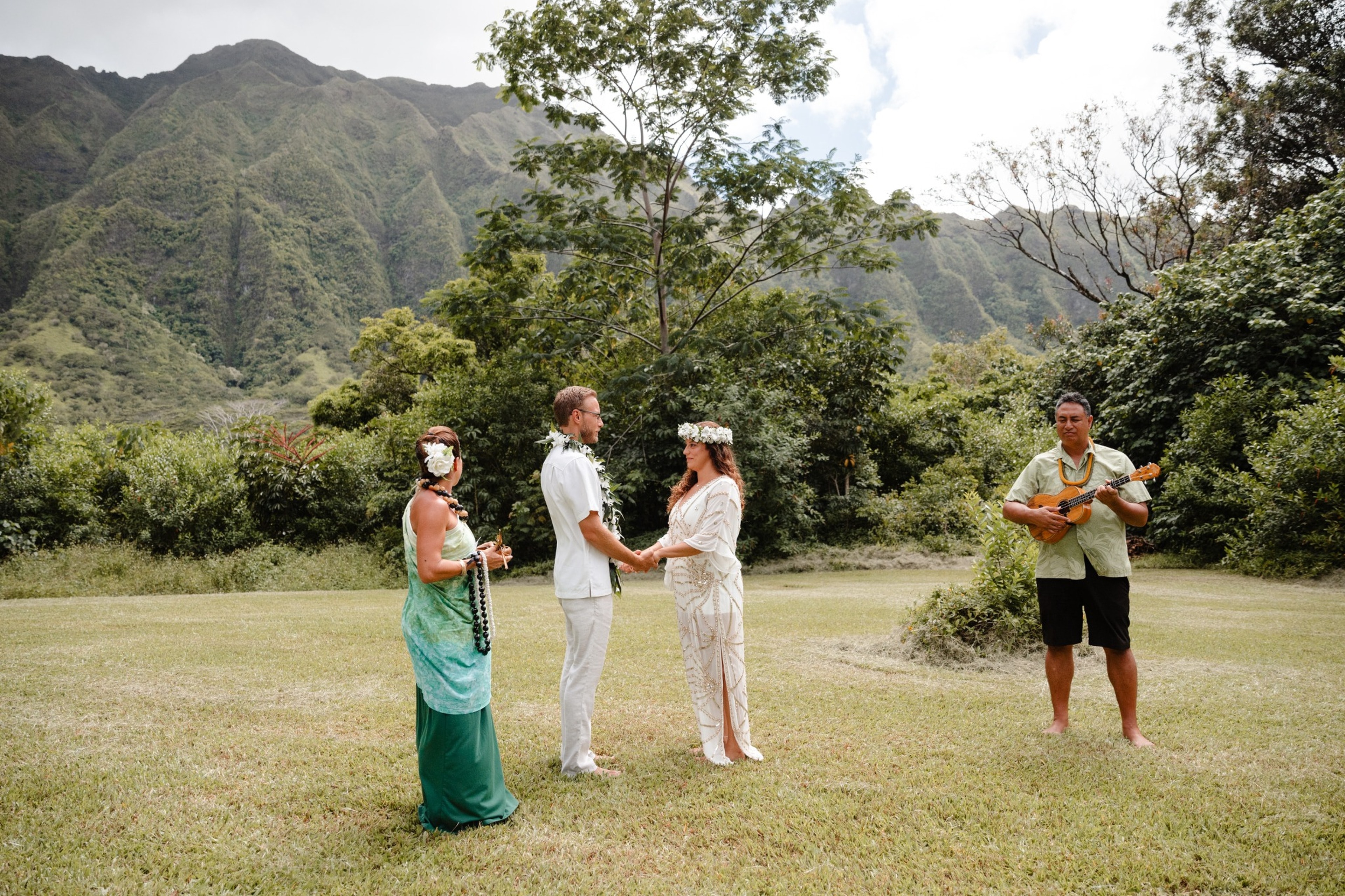 An intimate ceremony on a lawn with an officiant and a ukulele player